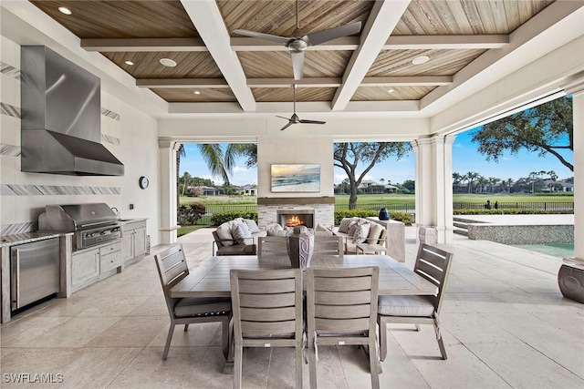 view of patio with ceiling fan, a grill, exterior kitchen, and exterior fireplace