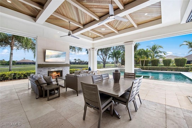 interior space featuring an outdoor living space with a fireplace, ceiling fan, and pool water feature