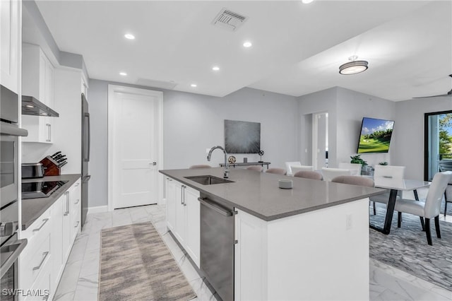 kitchen with sink, white cabinetry, an island with sink, and appliances with stainless steel finishes