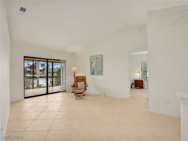 living area with high vaulted ceiling and light tile patterned floors