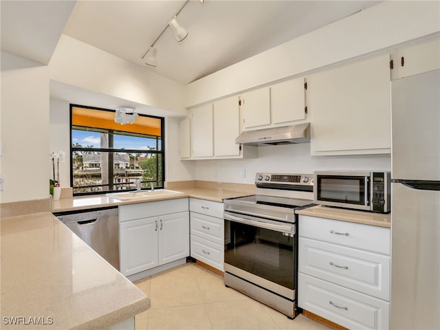 kitchen with rail lighting, sink, white cabinetry, light tile patterned floors, and stainless steel appliances