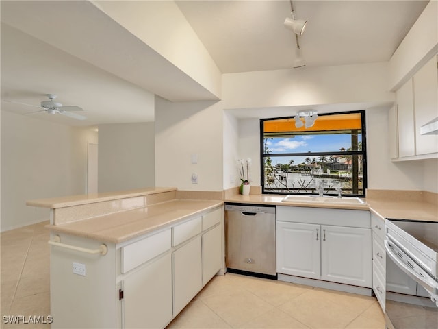 kitchen with sink, light tile patterned floors, dishwasher, kitchen peninsula, and white cabinets