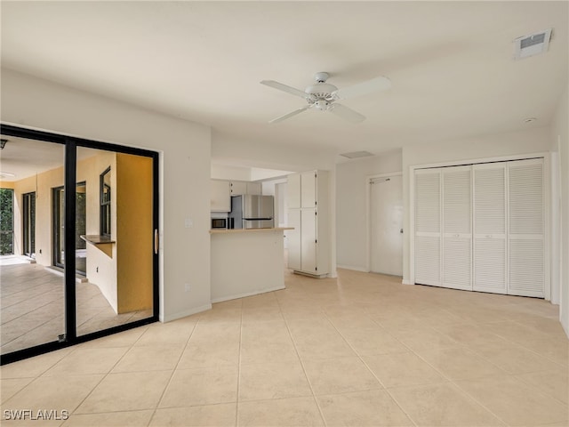 unfurnished living room with light tile patterned floors and ceiling fan