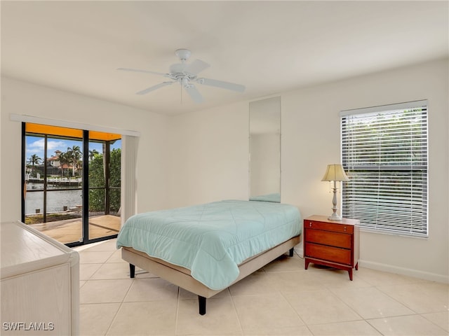 tiled bedroom with a water view, ceiling fan, access to exterior, and multiple windows