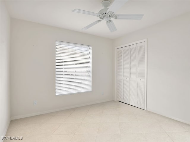 unfurnished bedroom featuring light tile patterned flooring, ceiling fan, and a closet