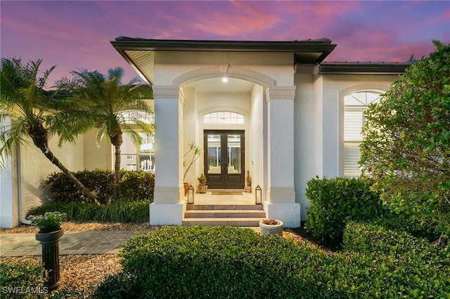 exterior entry at dusk featuring french doors