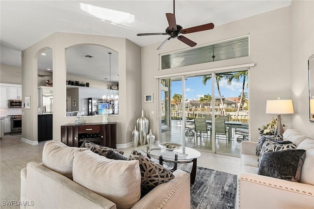 living room featuring ceiling fan with notable chandelier