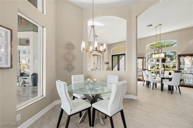 dining space featuring light wood-type flooring and a chandelier