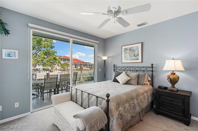 carpeted bedroom featuring access to outside, ceiling fan, and a water view