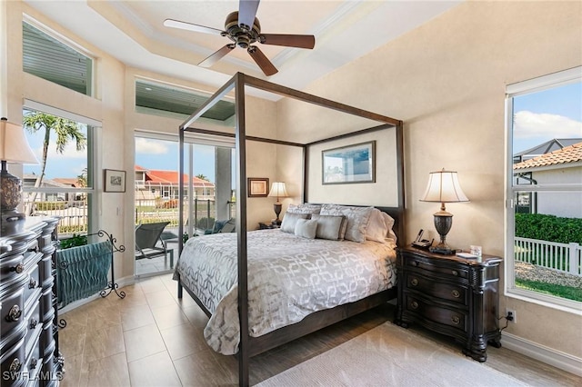 bedroom featuring access to exterior, ceiling fan, and a raised ceiling