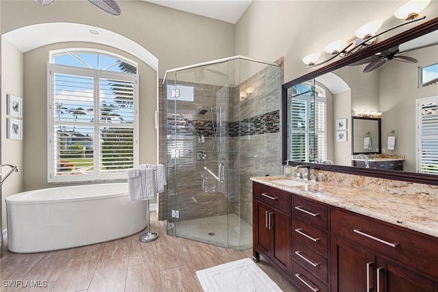 bathroom featuring vanity, plenty of natural light, ceiling fan, and separate shower and tub