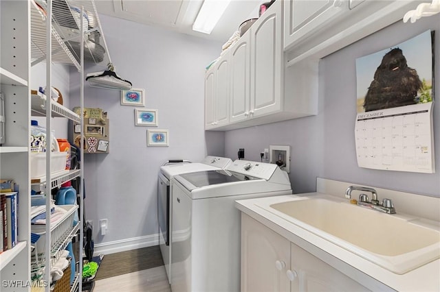 clothes washing area with cabinets, sink, dark wood-type flooring, and washing machine and clothes dryer