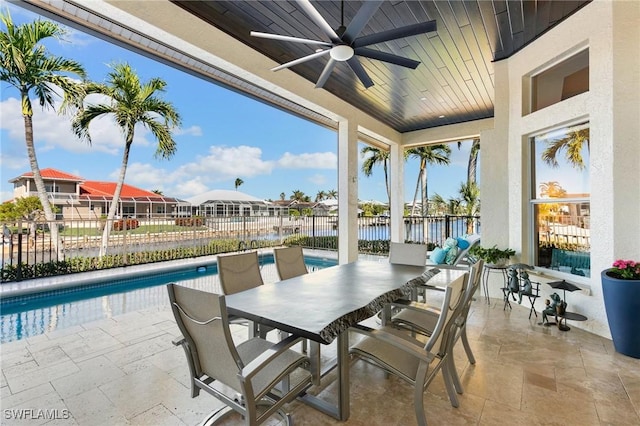 view of patio featuring ceiling fan, a fenced in pool, and a water view