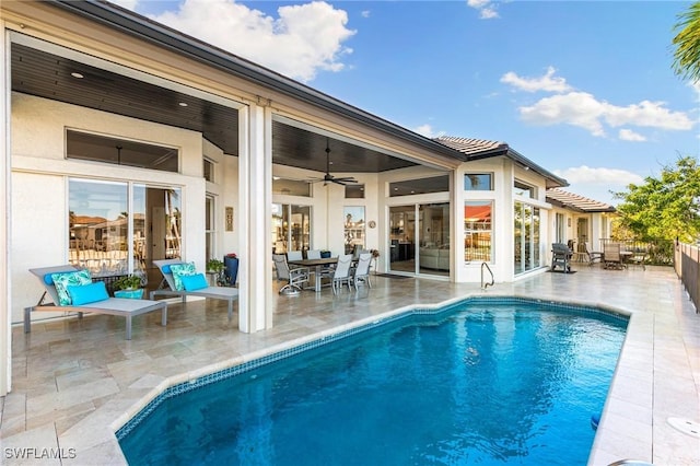 view of swimming pool featuring ceiling fan and a patio