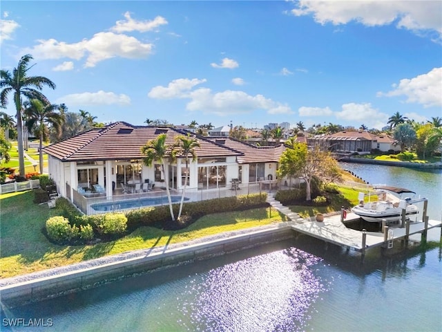 rear view of property featuring a lawn, a patio area, and a water view