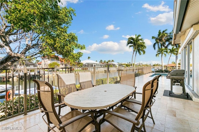 view of patio / terrace featuring a water view, grilling area, and a fenced in pool