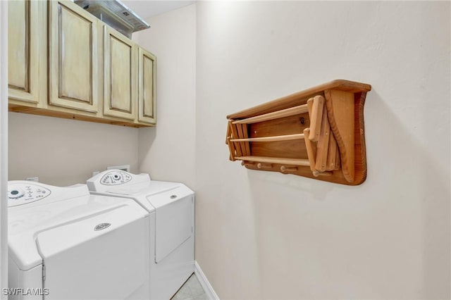 clothes washing area featuring cabinets and washer and clothes dryer