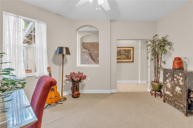 living area with carpet floors and ceiling fan