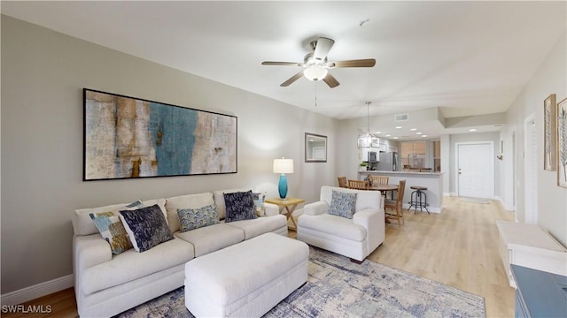 living room featuring ceiling fan and light hardwood / wood-style floors