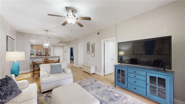 living room featuring light hardwood / wood-style flooring and ceiling fan