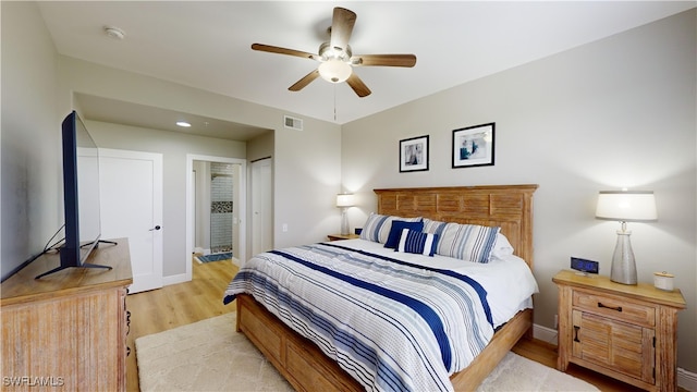 bedroom featuring connected bathroom, ceiling fan, a closet, and light hardwood / wood-style floors