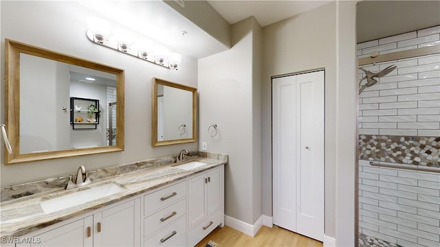 bathroom featuring tiled shower and vanity