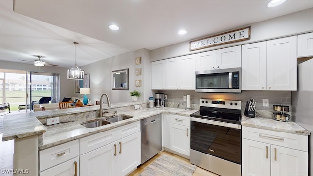 kitchen with white cabinetry, sink, kitchen peninsula, and stainless steel appliances