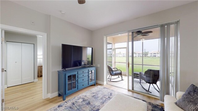 living room with light wood-type flooring and ceiling fan