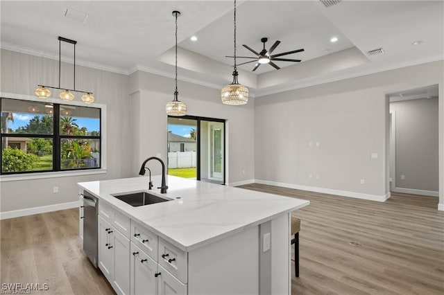 kitchen with white cabinets, a raised ceiling, dishwasher, and sink