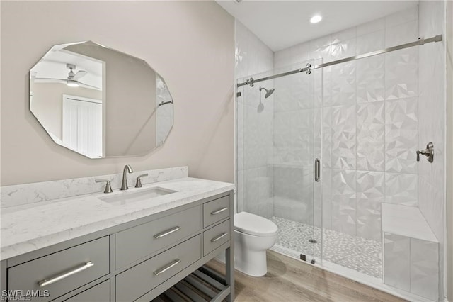 bathroom with vanity, hardwood / wood-style flooring, toilet, and an enclosed shower