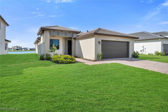 view of front facade featuring a front yard, a water view, and a garage