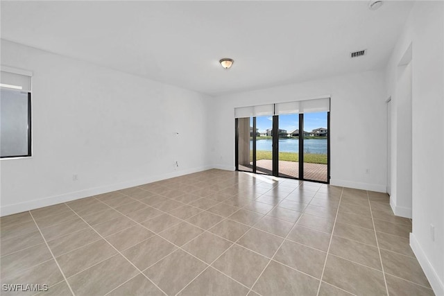 tiled spare room with a water view