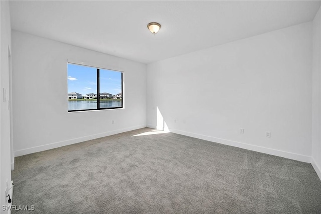 empty room with carpet flooring and a water view