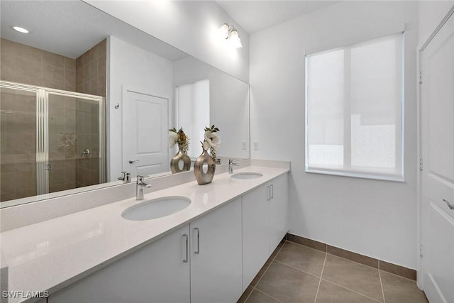 bathroom with tile patterned floors, vanity, and a shower with door