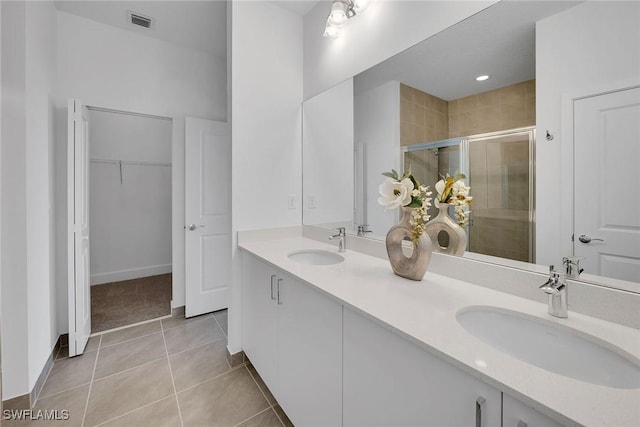 bathroom with tile patterned floors, vanity, and a shower with shower door