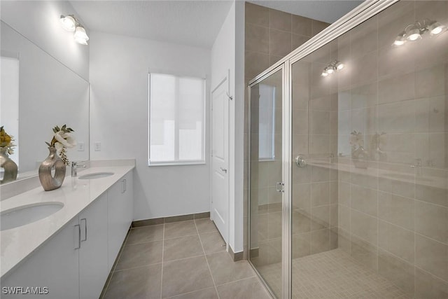 bathroom featuring tile patterned floors, a shower with door, and vanity