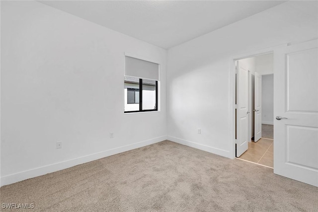 unfurnished room featuring light colored carpet