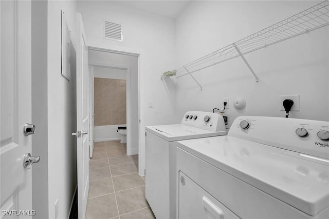 laundry room featuring light tile patterned floors and washing machine and clothes dryer