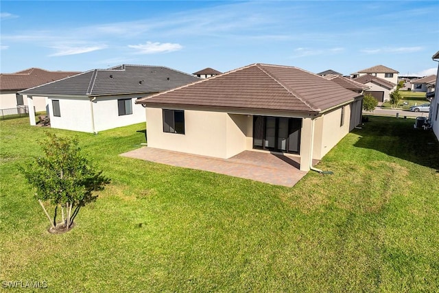 rear view of property featuring a yard and a patio