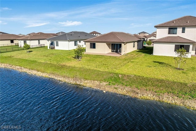 rear view of property with a yard, a water view, and a patio area