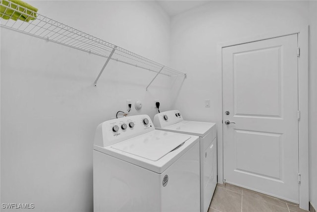 clothes washing area with separate washer and dryer and light tile patterned floors