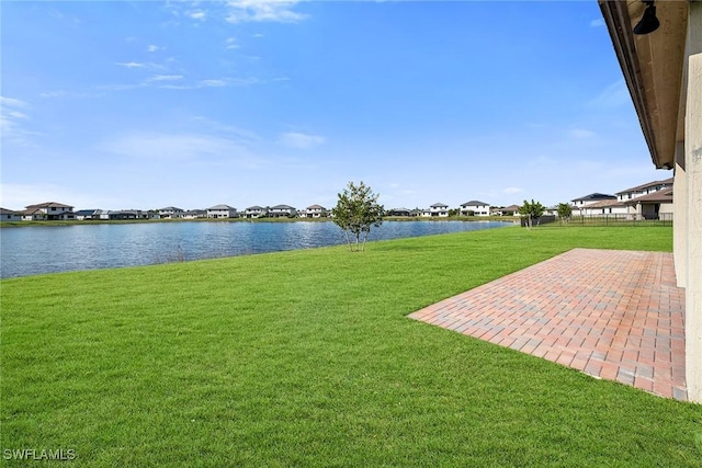 view of yard with a water view and a patio