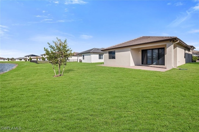 rear view of house featuring a yard and a patio area