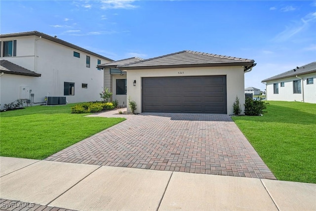 view of front facade with central AC, a front lawn, and a garage