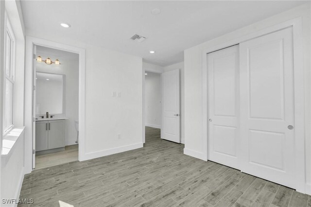 3190 Shell Mound Blvd, Fort Myers Beach, FL 33931 - unfurnished bedroom featuring recessed lighting, baseboards, visible vents, connected bathroom, and light wood-type flooring