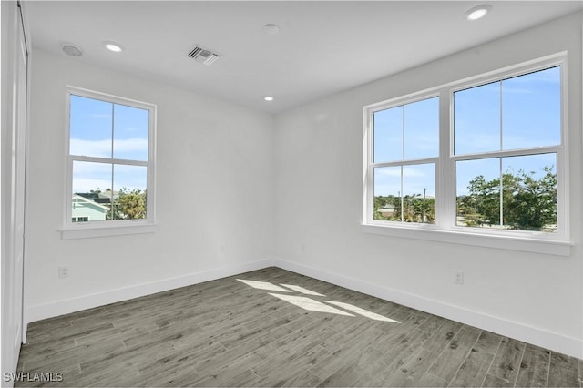 unfurnished room featuring a wealth of natural light and hardwood / wood-style flooring