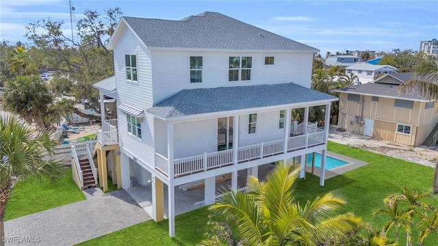 rear view of house featuring a yard, a carport, and a balcony