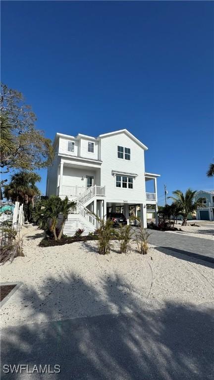 view of front facade featuring a carport, driveway, and stairs