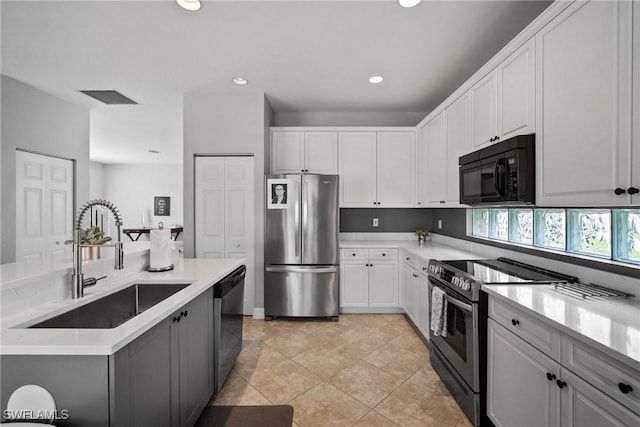 kitchen featuring sink, white cabinetry, stainless steel appliances, and light tile patterned floors