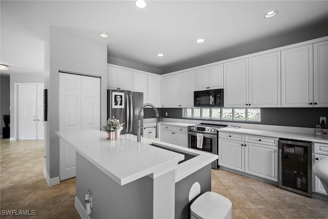 kitchen with wine cooler, a center island with sink, stainless steel appliances, and sink